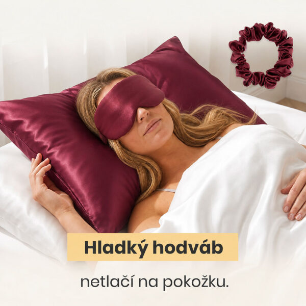 Žena spí na bordovej hodvábnej obliečke s maskou na spanie a gumičkou do vlasov